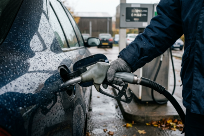 Driver refuelling a car in the rain, illustrating rising UK inflation driven by fuel prices