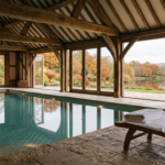 Indoor spa pool with oak beams overlooking a garden lake, illustrating the sale of a Surrey country hotel and spa