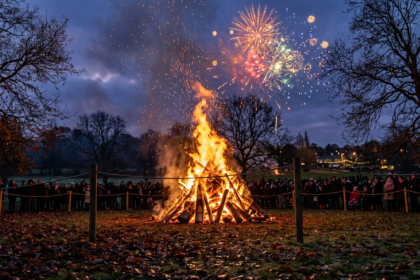 Community bonfire and fireworks at dusk in an English park, illustrating the history of Bonfire Night