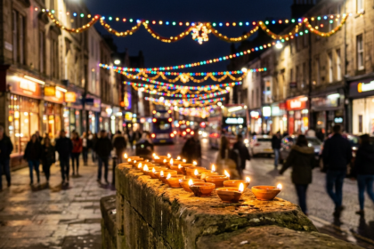Lit diya lamps in front of a British high street strung with festive lights, illustrating Diwali in Britain