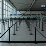 Empty airport passport control hall with queue barriers, illustrating the UK-EU free movement debate