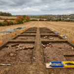 Archaeological trenches in an English field near a motorway, illustrating the Roman burial ground found by the M5